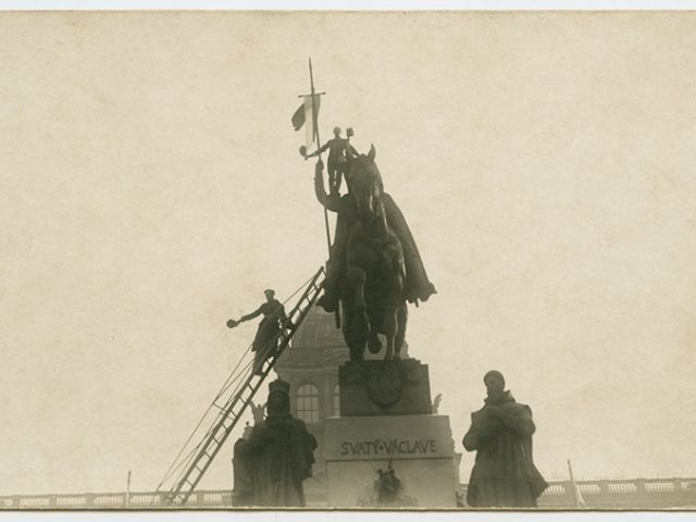 Václavské náměstí, 29. října 1918. Dobový popisek: "I sv. Václav vztýčil prapor červeno-bílý”.