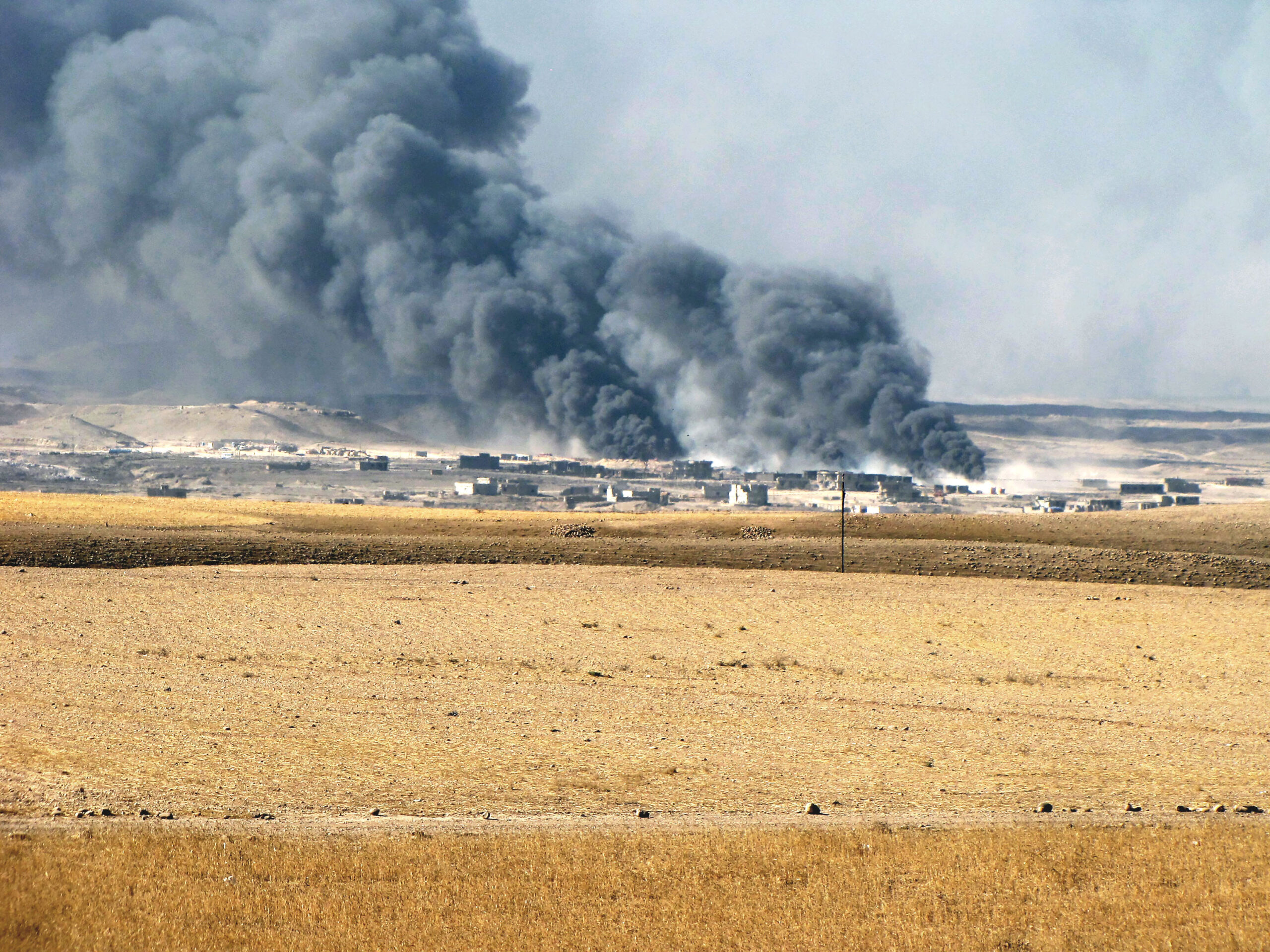 Dým z hořících ropných vrtů, které zapálili ustupující islamisté.