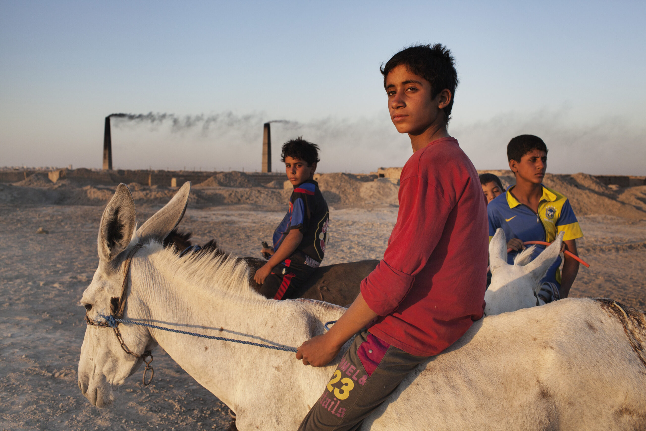 Děti pracující v silně znečištěné cihelně. Nadžaf, Irák, červenec 2013.