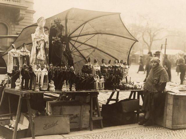 Dívka na mikulášském trhu v Praze, kolem roku 1912.