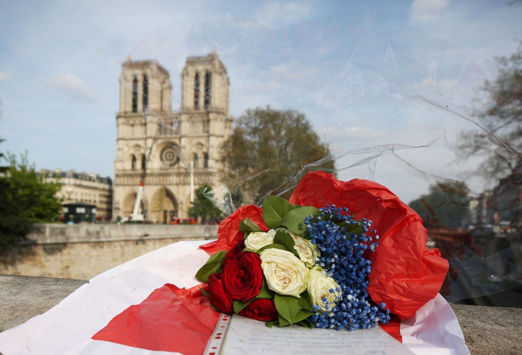 Květiny u pařížské katedrály Notre-Dame krátce po jejím velkém požáru.