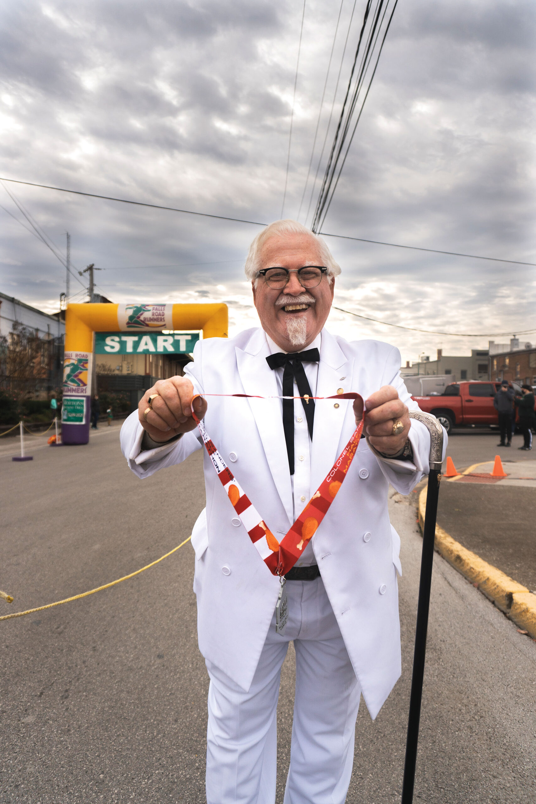 Město Corbin, Kentucky. Vítězi půlmaratonu gratuluje muž v kostýmu plukovníka Sanderse.