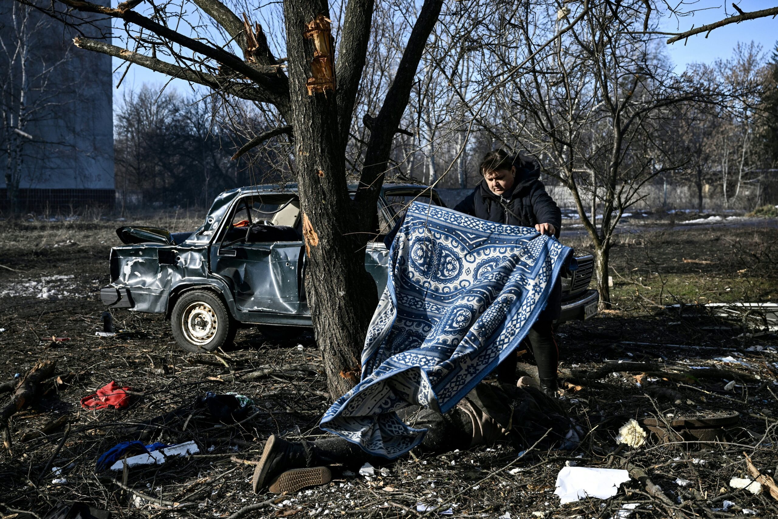 Žena přikrývá jednu z obětí ruského útoku na ukrajinské město Čuhujiv, které leží pětatřicet kilometrů od Charkova.