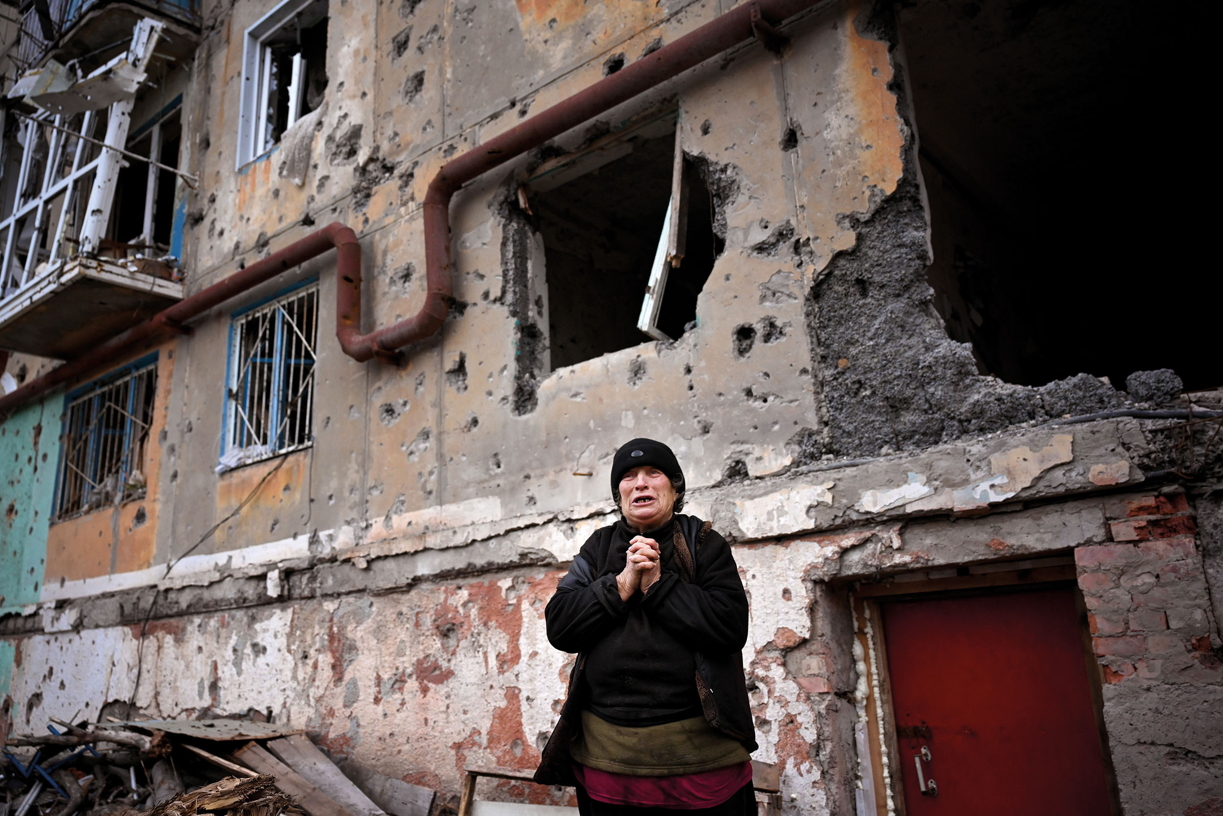 Jednasedmdesátiletá Káťa před zbytky svého domu ve Vuhledaru.